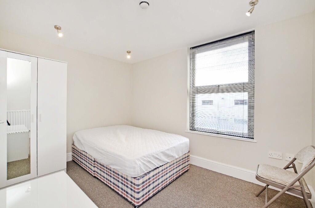 Bright and clean master bedroom featuring a com...