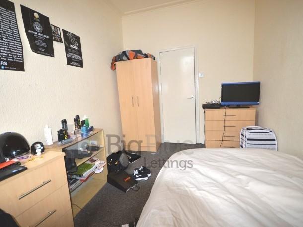 A cozy single bedroom featuring a neatly made b...