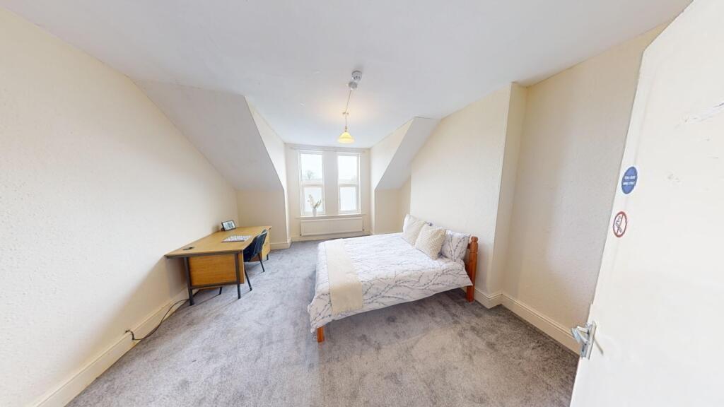 A bright and neat double bedroom featuring a co...