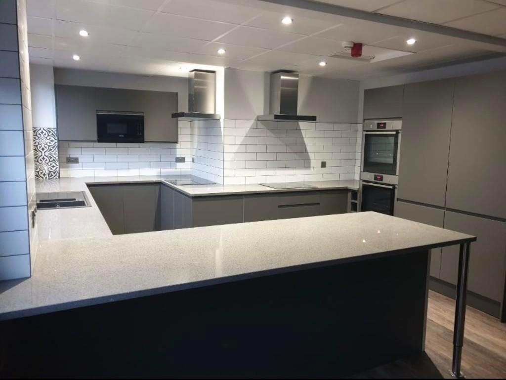 A modern kitchen featuring sleek grey cabinetry...