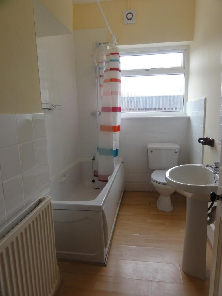 A clean, well-maintained bathroom with a bathtu...