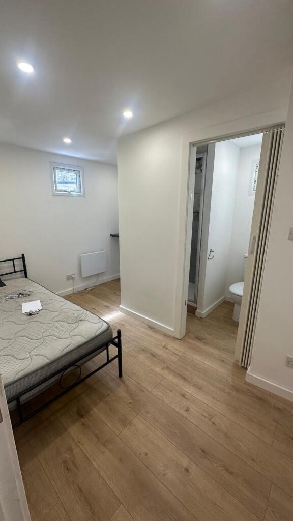 A clean and simple room featuring a bed and an ...
