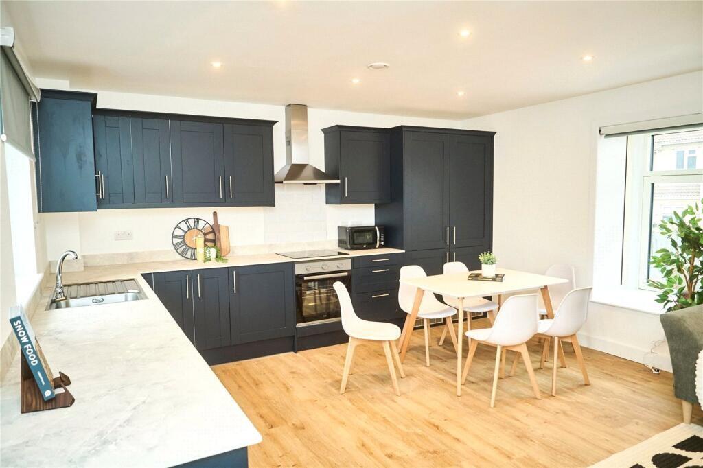 Bright and modern kitchen with sleek black cabi...