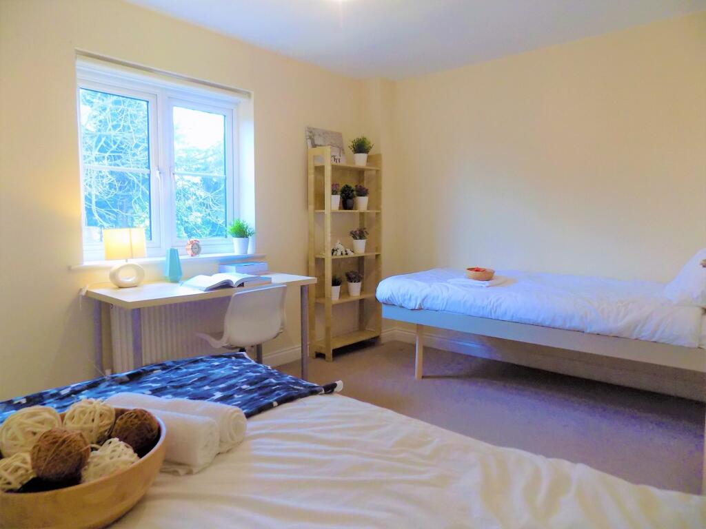 A bright and tidy double bedroom featuring two ...