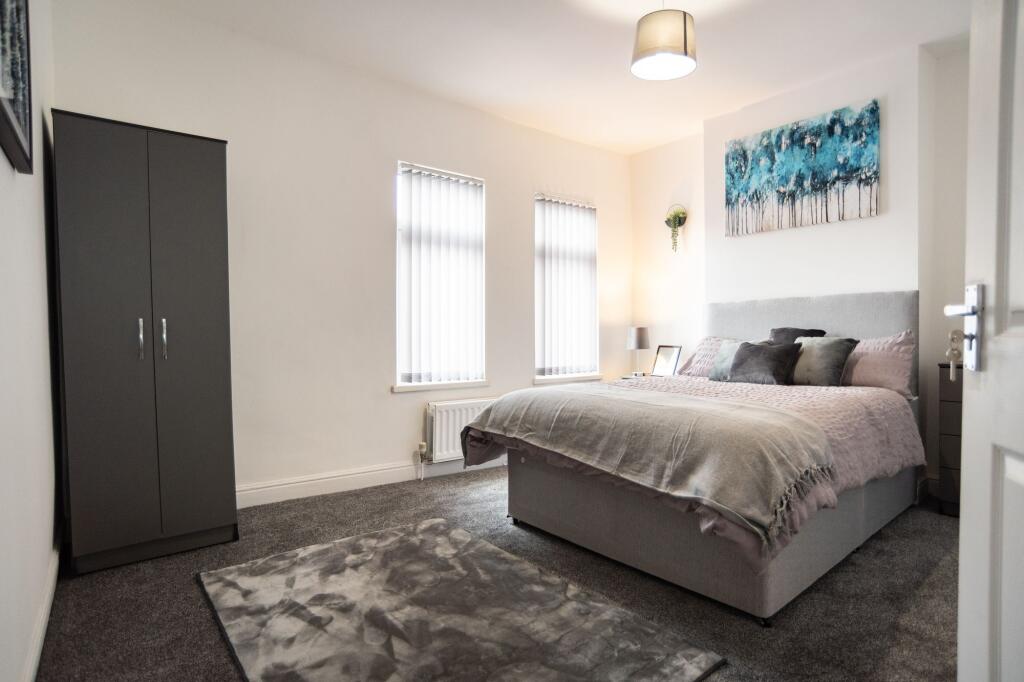Bright and cozy master bedroom featuring a styl...