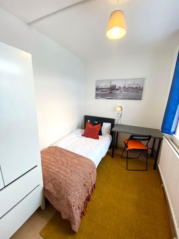 A cozy, well-kept single bedroom featuring a co...