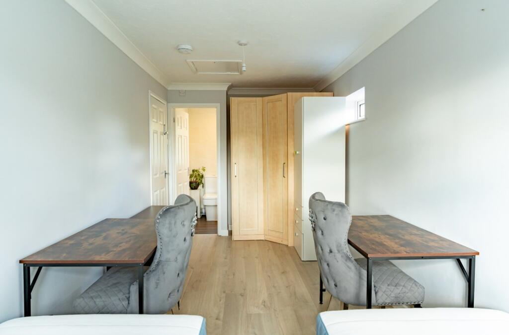 A bright and tidy double bedroom featuring two ...