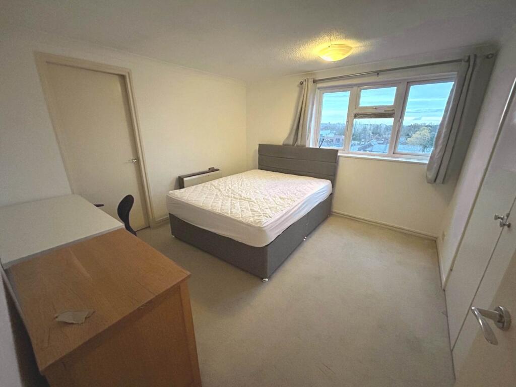 Bright, neutrally decorated double bedroom with...