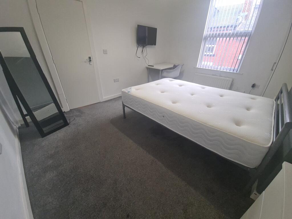 A bright and tidy bedroom featuring a well-made...