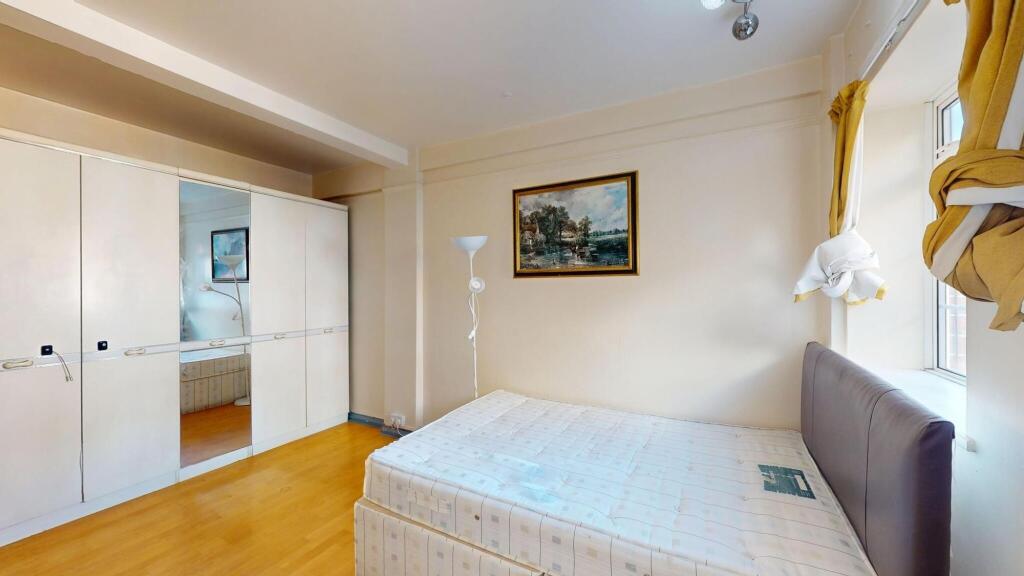 A cozy bedroom featuring a bed with a headboard...