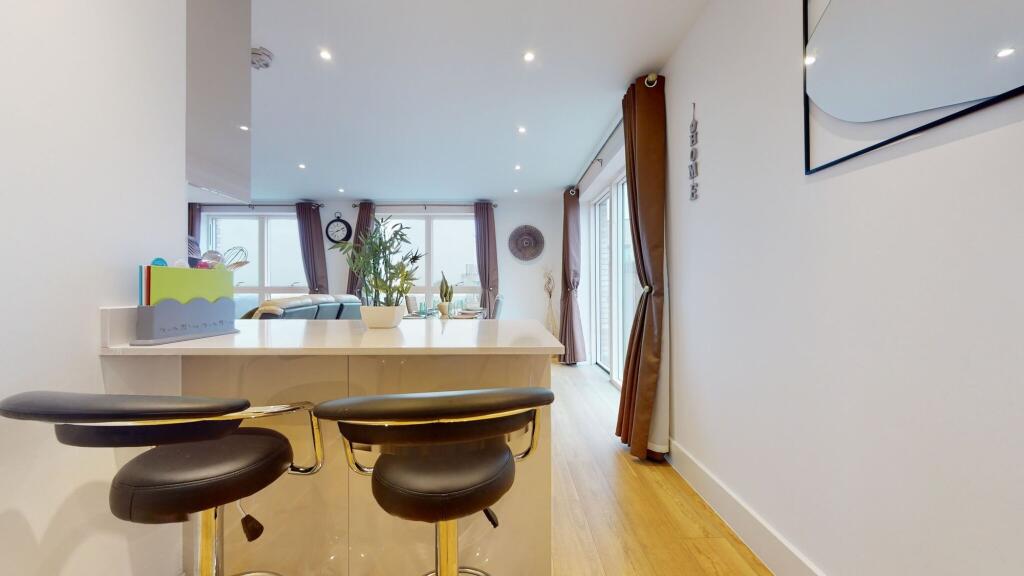 A bright and modern living room featuring large...