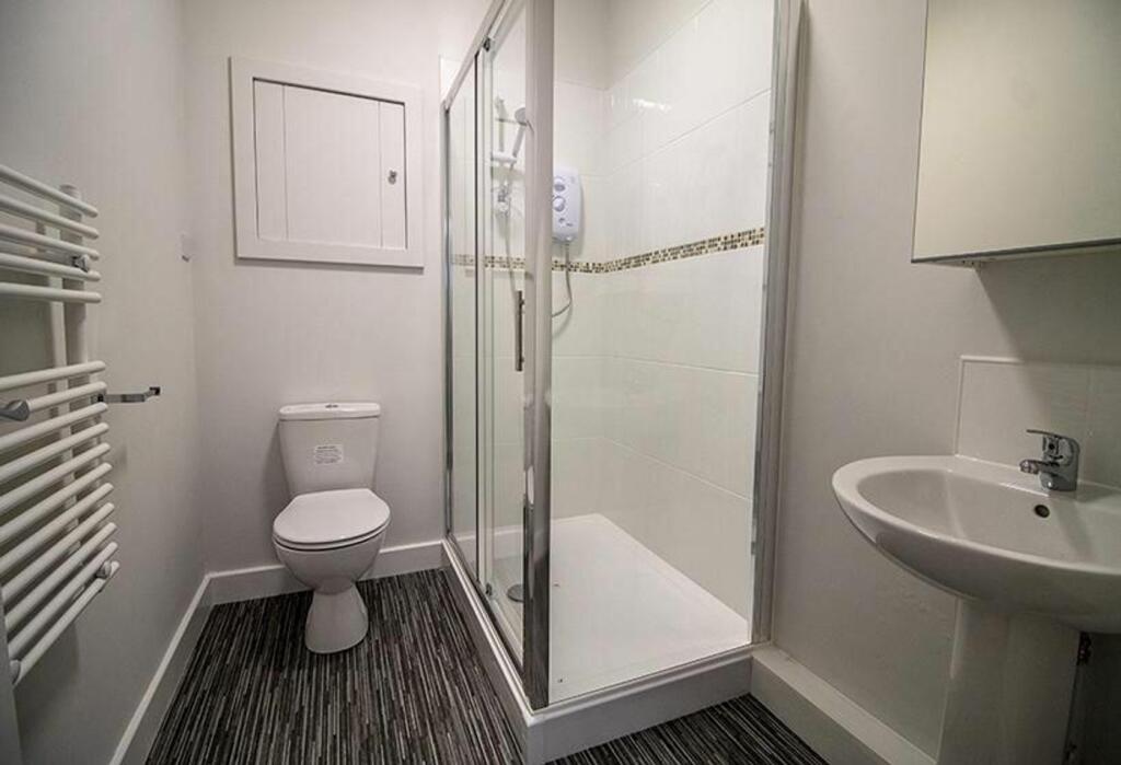 A modern bathroom featuring a spacious shower, ...