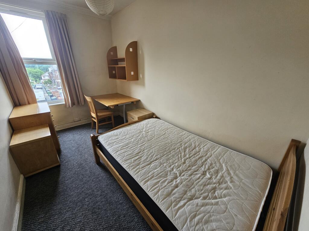 A bright and tidy single bedroom featuring a la...