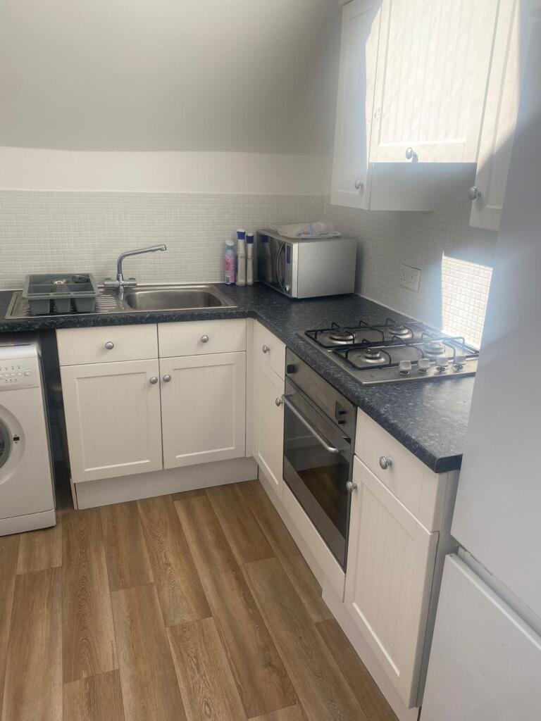 Bright and functional kitchen with white cabine...