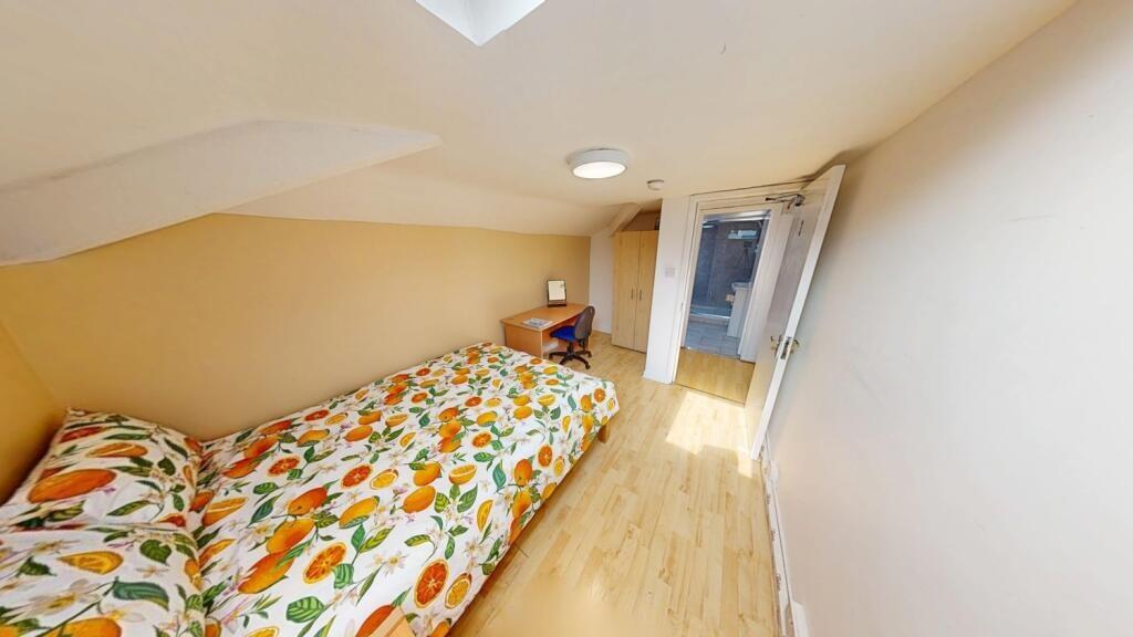 A cozy single bedroom with a floral patterned b...