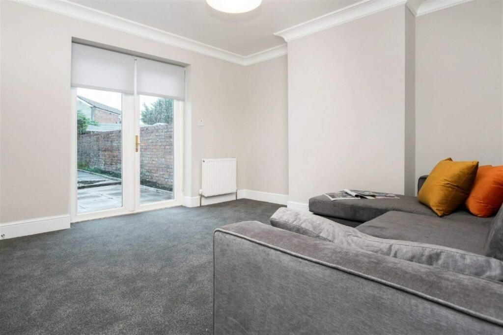 A bright and tidy living room featuring a spaci...