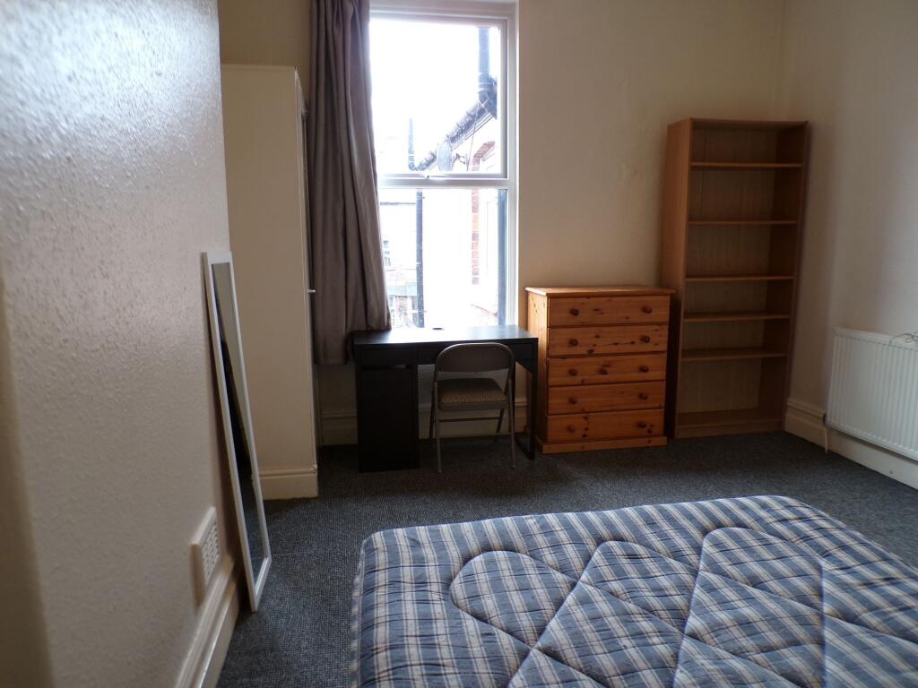 A cozy bedroom featuring a window allowing for ...