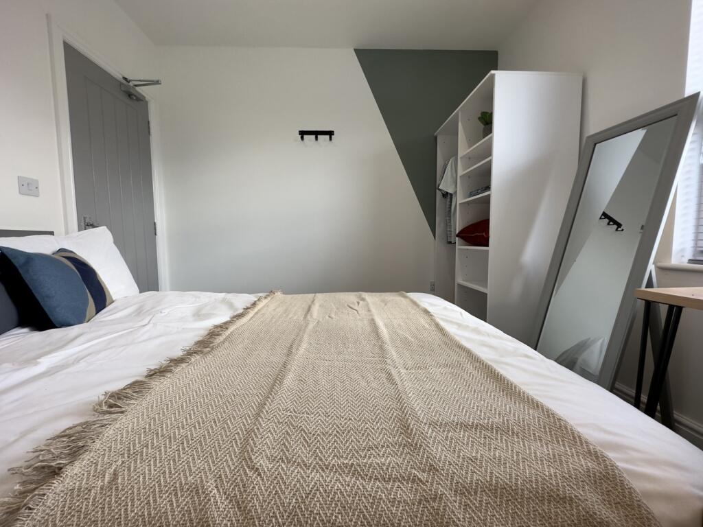 A cozy and well-arranged double bedroom with a ...