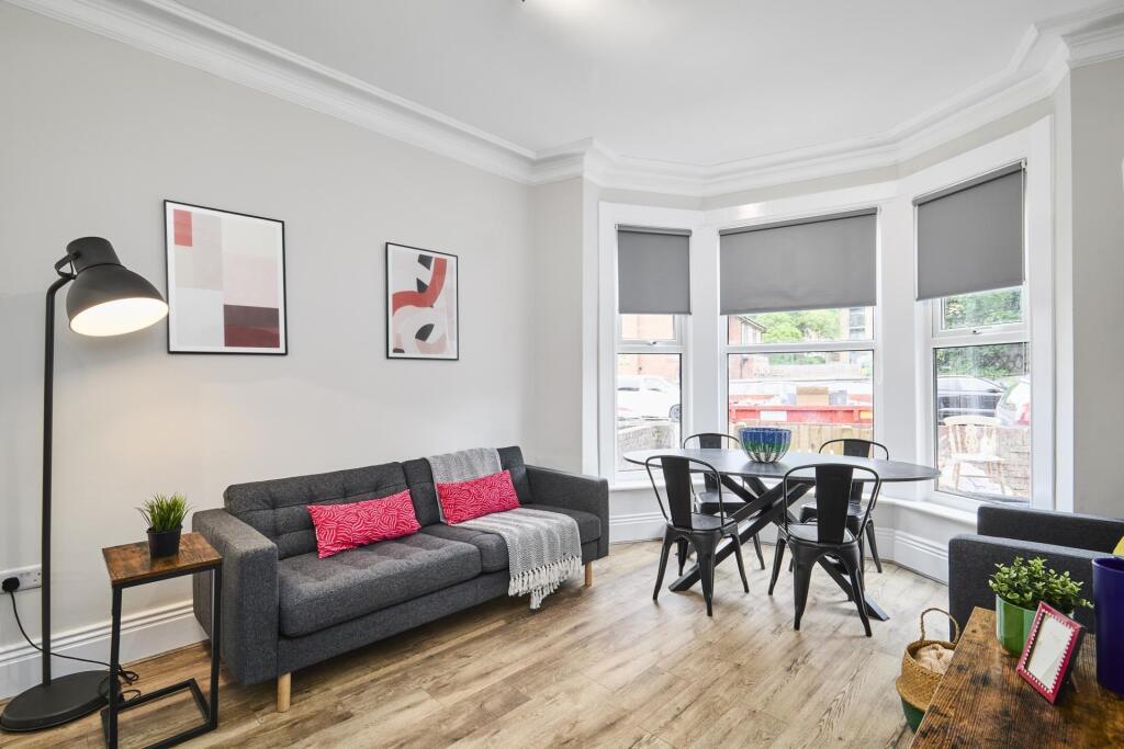 A spacious and well-lit living room with modern...