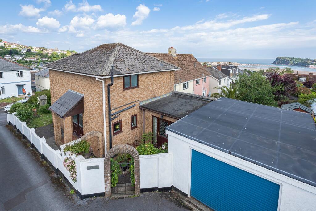 Rear of property with sea views beyond and garage