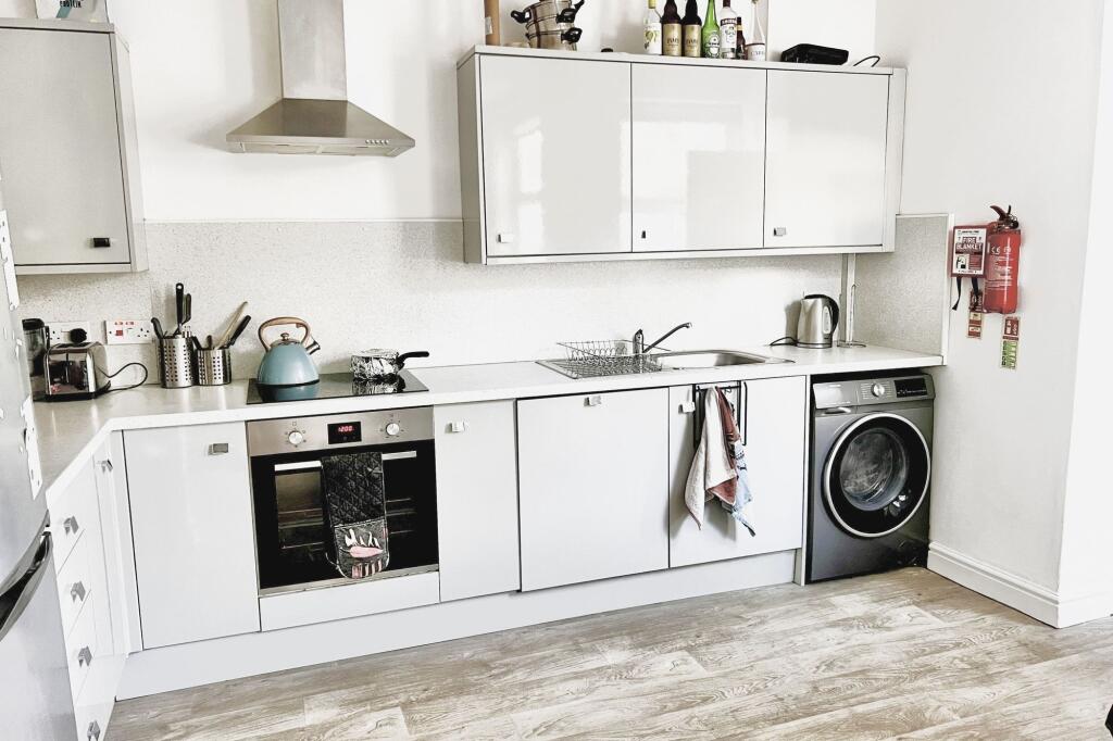 Bright and modern kitchen featuring white cabin...