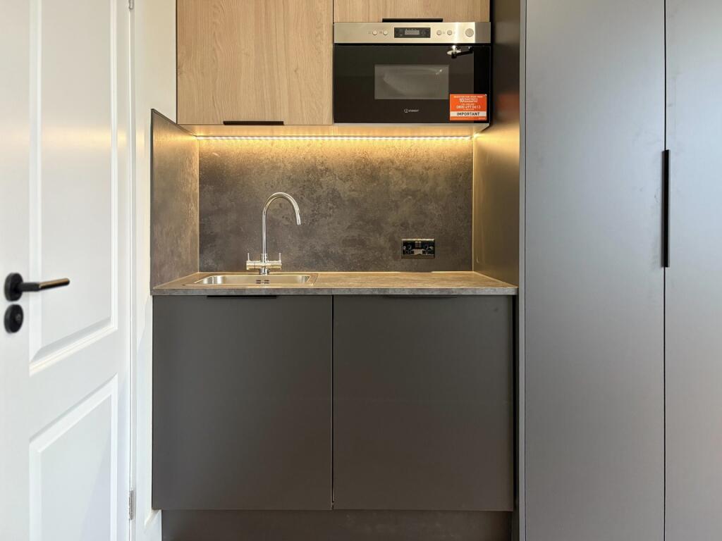 Compact modern kitchenette with integrated oven...
