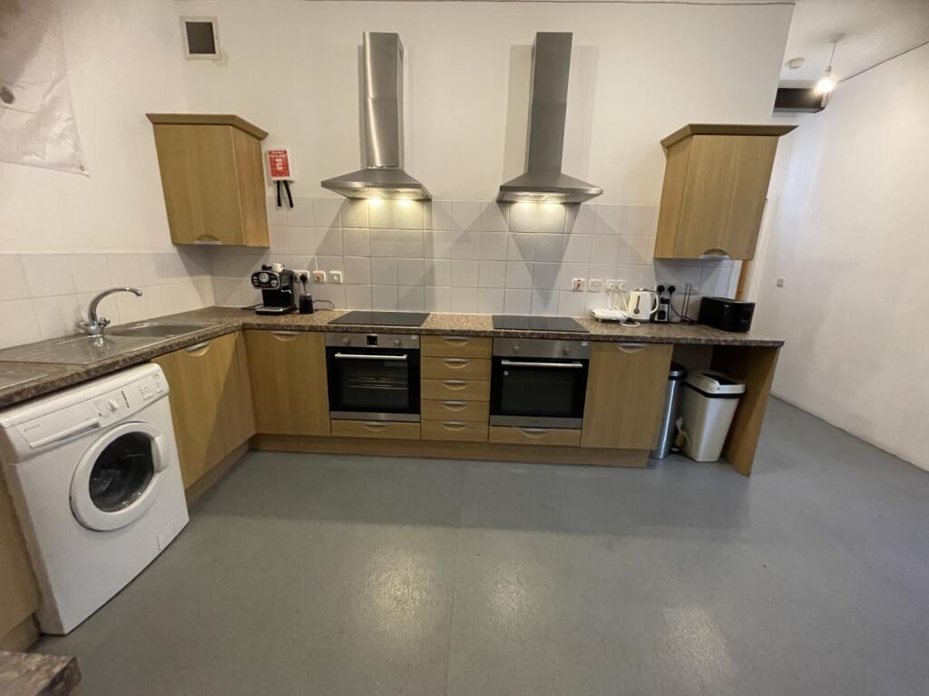 A modern kitchen featuring dual ovens and hobs,...