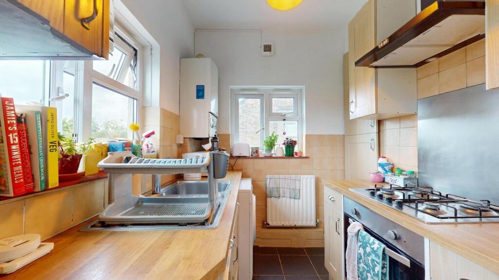 Bright and tidy kitchen featuring large windows...