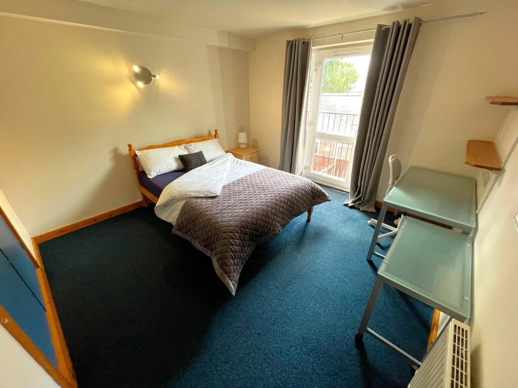 A spacious and inviting double bedroom with nat...