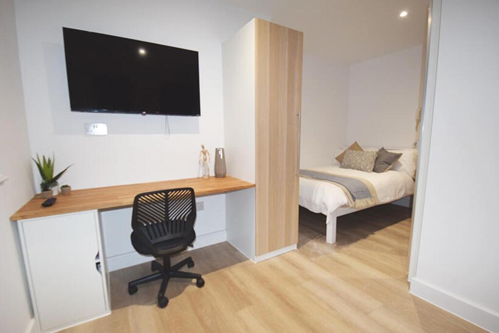 This inviting double bedroom features a cozy be...