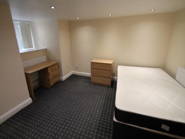 A neatly arranged single bedroom featuring a be...