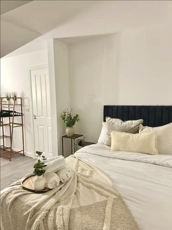 A beautifully styled master bedroom featuring a...