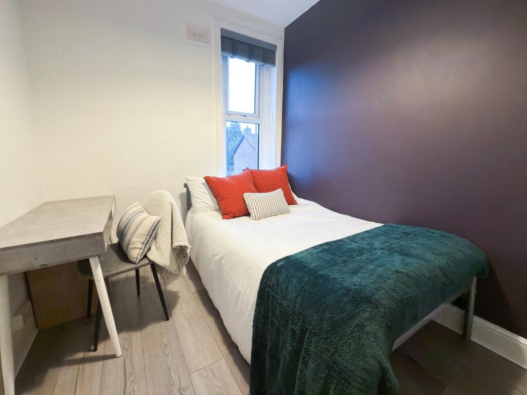 A cozy single bedroom featuring a comfortable b...