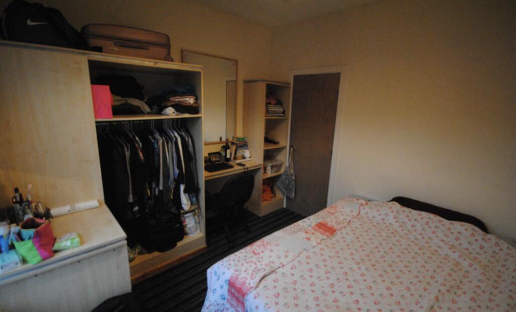 A spacious double bedroom featuring a neatly ma...