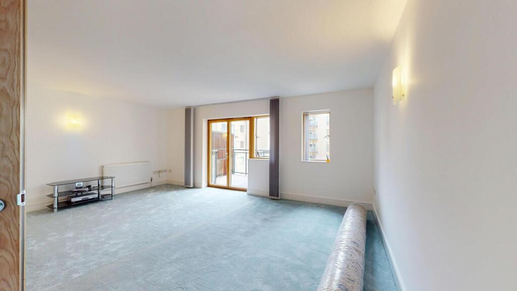 Bright and spacious living area with large wind...
