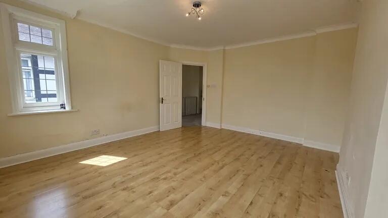 Bright and spacious living room with warm woode...