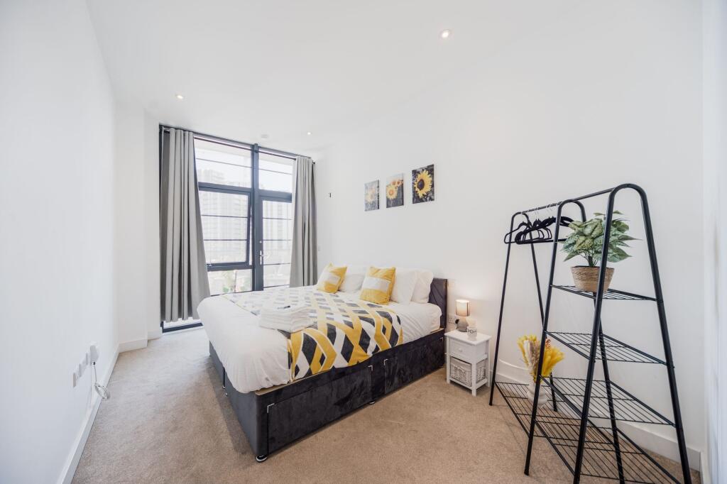 Bright and modern master bedroom featuring a la...