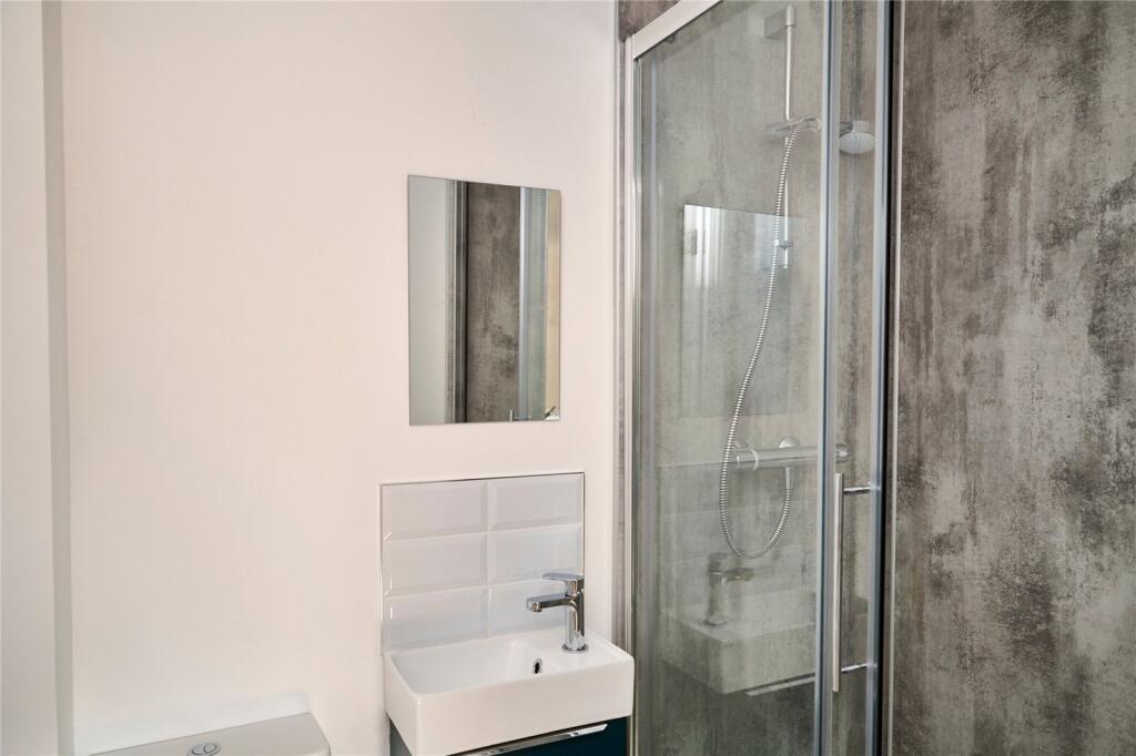 A modern bathroom featuring a clear glass showe...