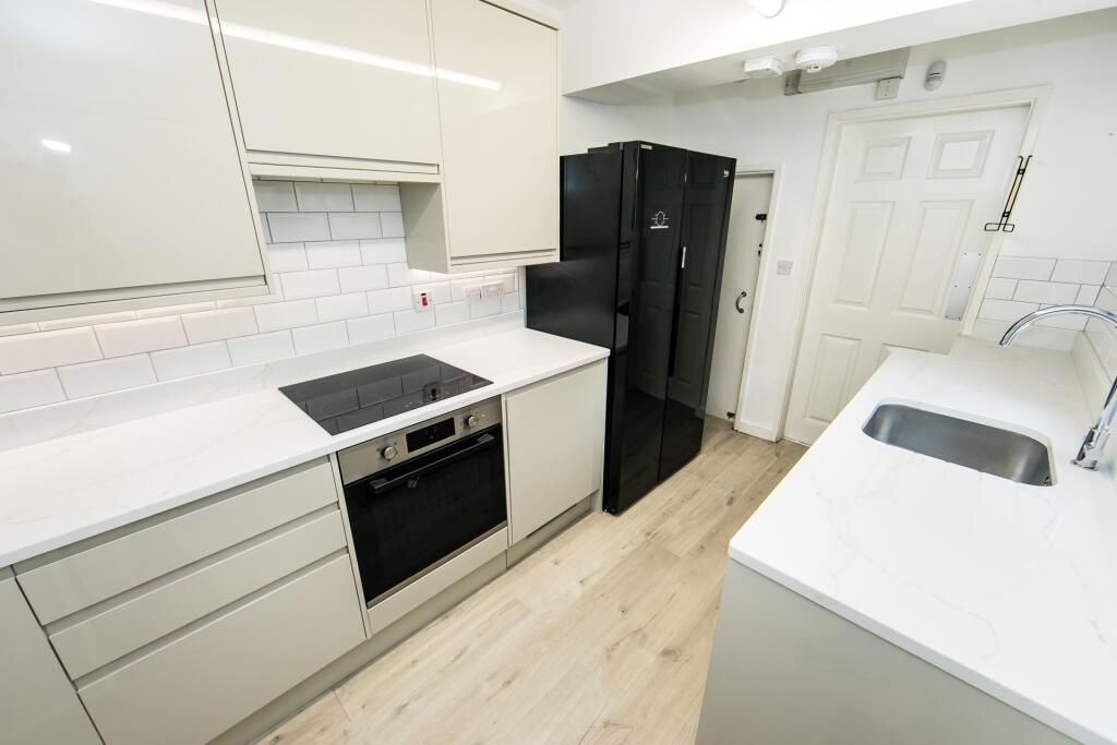 A bright and clean kitchen featuring modern whi...
