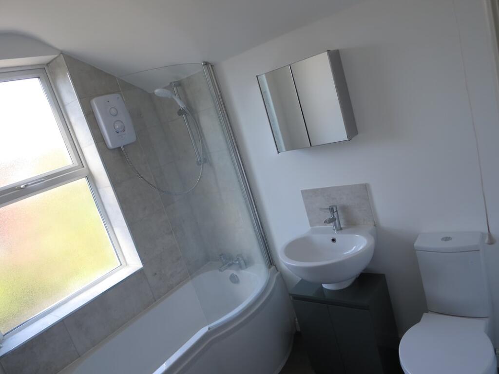 Bright and modern bathroom suite featuring a cu...