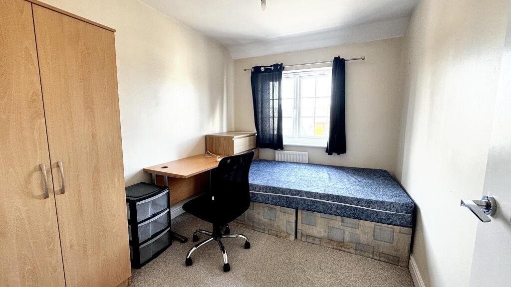 Cozy single bedroom featuring a built-in desk w...