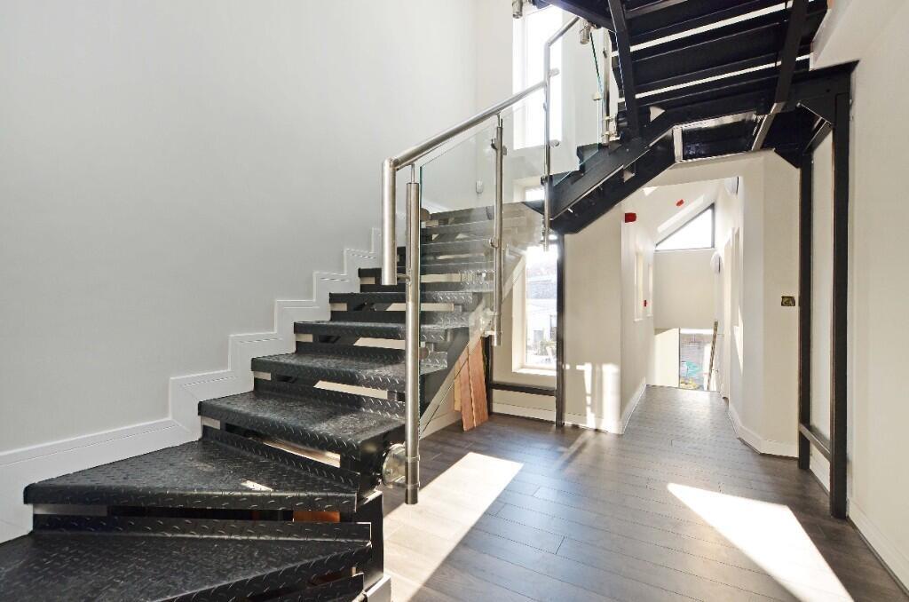 Bright and modern staircase area with stylish g...