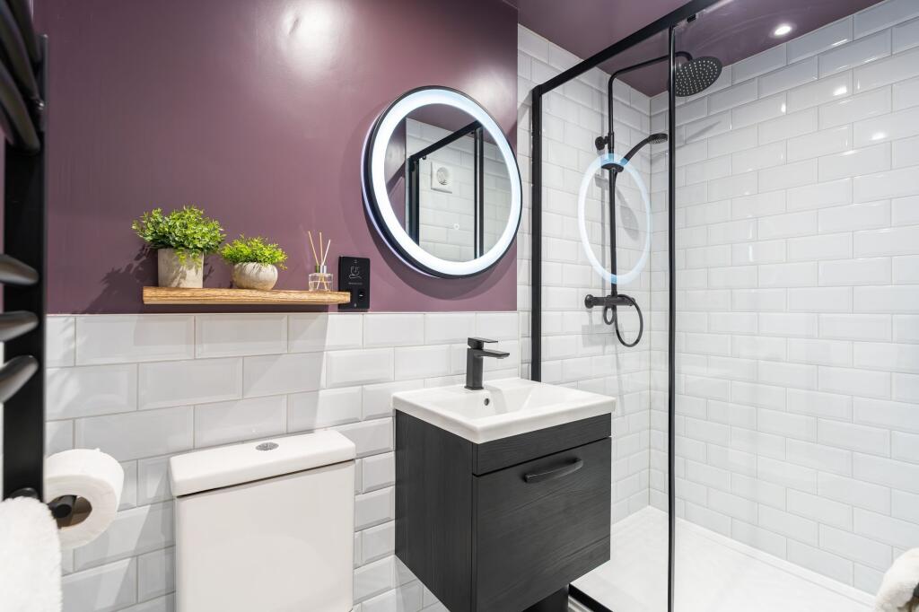Modern and stylish bathroom featuring white til...