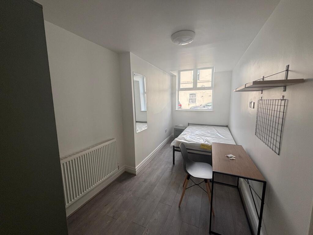 This cozy double bedroom features ample natural...