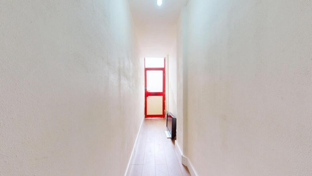 Bright and clean hallway featuring a red-framed...