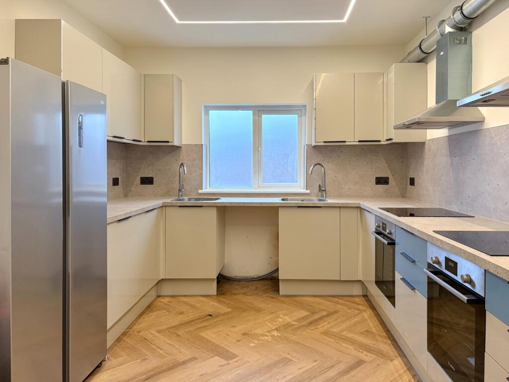 Bright, modern kitchen with sleek white cabinet...