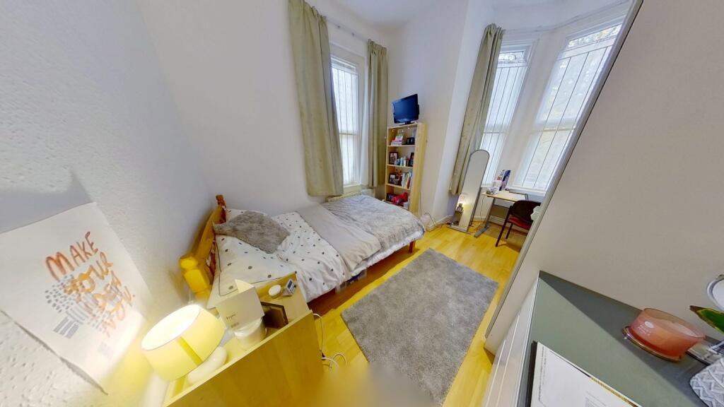 A cozy single bedroom featuring a single bed, a...