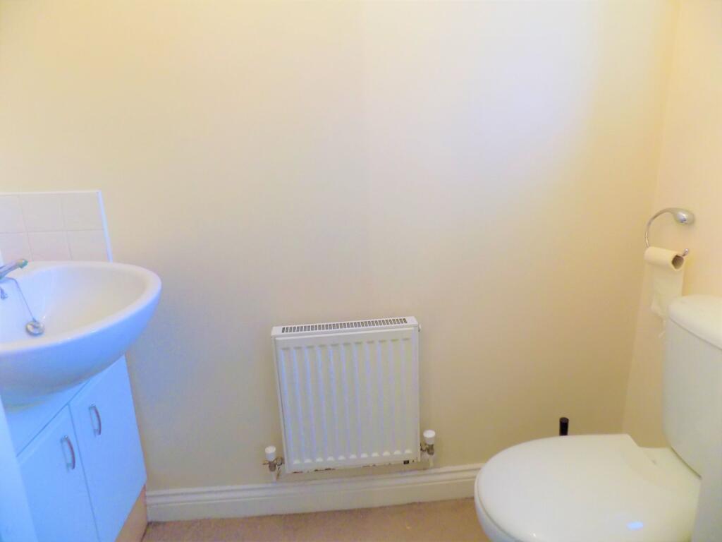 A clean and simple toilet room featuring a whit...