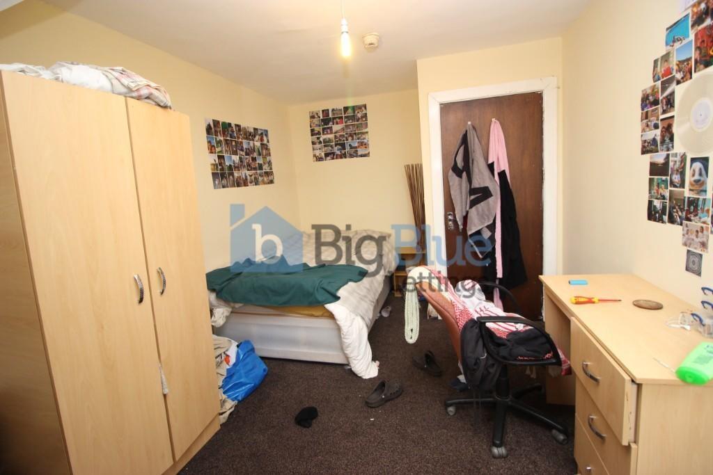Cozy single bedroom featuring essential furnish...