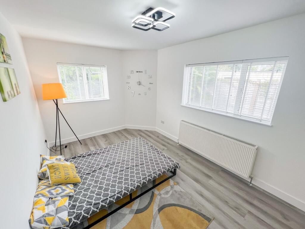 A bright and clean single bedroom featuring con...